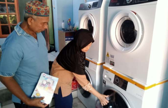 Musim hujan omzet pengusaha laundry atau binatu naik drastis, memunculkan bisnis binatu dadakan. Kang latif bersama istri  kewalahan melayani pelanggan Dora Laundry (Foto: Asmanu Sudarso/ngopibareng.id)