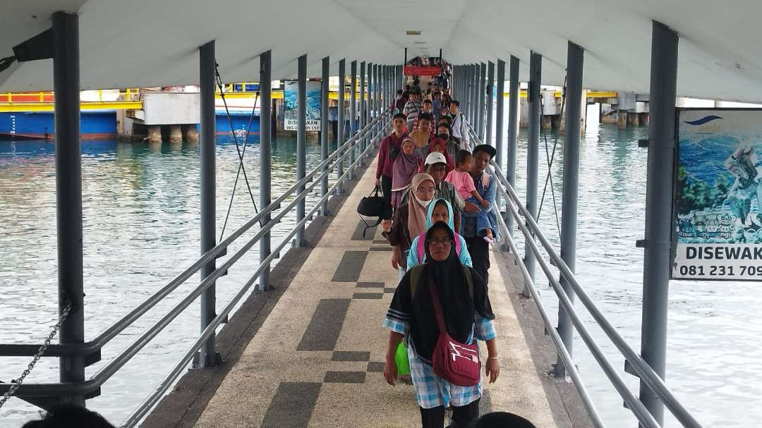 Para penumpang berjalan kaki turun dari kapal di Pelabuhan Ketapang. Mereka merupakan wisatawan yang pulang setelah liburan di Bali. (Foto: Muh Hujaini/Ngopibareng.id))