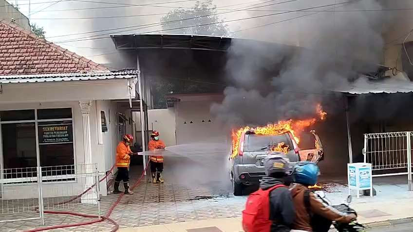 Kebakaran hebat menimpa sebuah mobil Nissan X-trail nopol AE 1321 GE di Jalan Thamrin Kota Madiun, Minggu, 5 Januari 2025. (Foto: Tova Pradana/Ngopibareng.id)