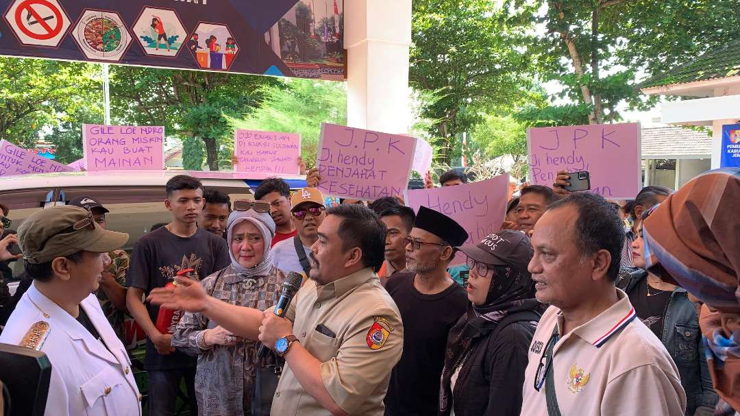 Puluhan warga menyampaikan aspirasinya di depan Kantor Dinas Kesehatan Jember, Jawa Timur. (Foto: Rusdi/Ngopibareng.id)