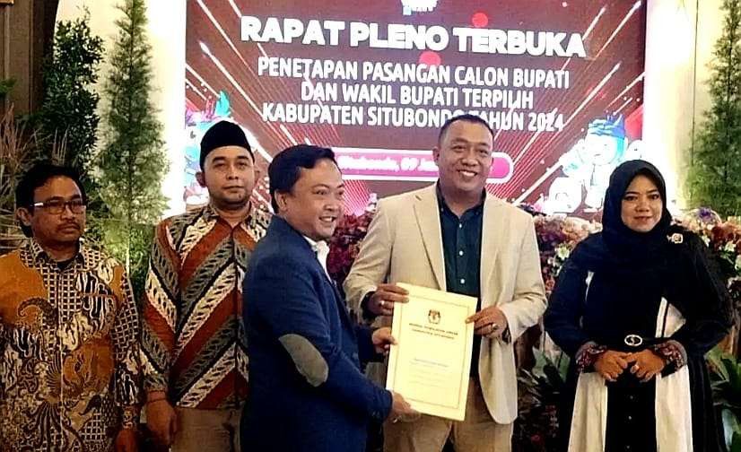 Pasangan Bupati dan Wabup Situbondo terpilih, Yusuf Rio Wahyu Prayogo dan Ulfiyah menerima surat penetapan dari Ketua KPU Situbondo, Hadi Prayitno. (Foto: Guido Saphan/Ngopibareng.id)