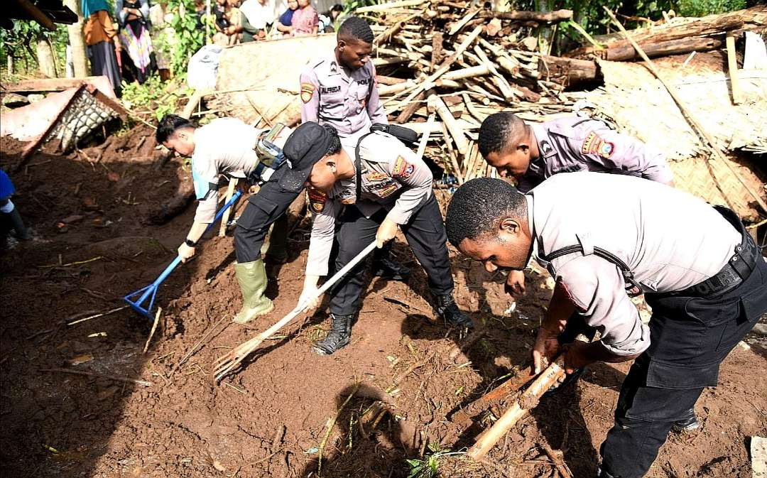 Ratusan anggota Polres Bondowoso gotong royong membersihkan material kayu dan lumpur pascabanjir bandang Maesan. (Foto: Guido Saphan/Ngopibareng.id)