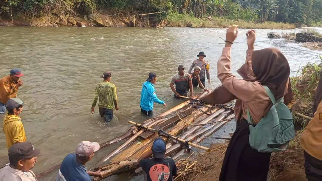 Anggota Polsek Tempurejo saat membantu siswa menyeberang menggunakan rakit (Foto: Dokumentasi Polsek Tempurejo)