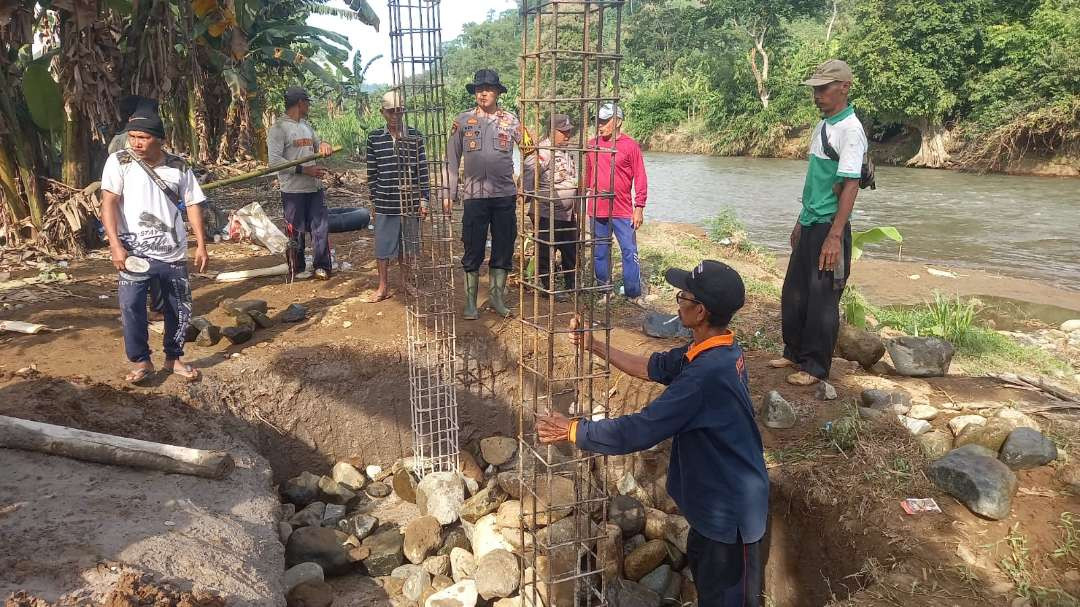 Masyarakat mulai membangun tiang jembatan secara swadaya (Foto: Dokumentasi Polsek Tempurejo)