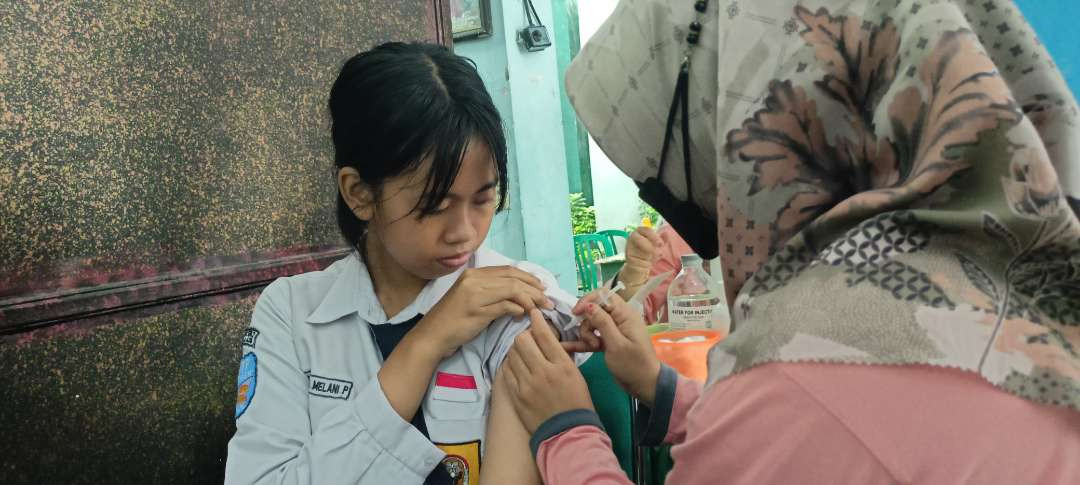 Petugas medis Dinas Kesehatan Kota Madiun melakukan vaksinasi Human Papillomavirus (HPV) kepada salah satu siswi SMPN 2 Kota Madiun. (Foto: Tova Pradana/Ngopibareng.id)