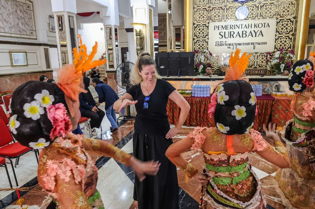 Salah satu wisatawan yang tampak bergembira bersama para penari tarian Goyang Jeder, di Balai Kota Surabaya. (Foto: Humas Pemkot Surabaya)
