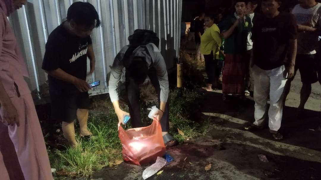 Petugas Polsek Giri sedang mengumpulkan barang bukti di lokasi kejadian (foto : Muh Hujaini/Ngopibareng.id)