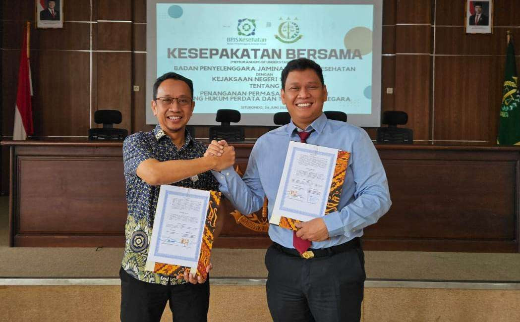 Kepala BPJS Kesehatan Cabang Banyuwangi, Titus Sri Hardianto dan Kepala Kejari Situbondo, Ginanjar Cahya Permana menunjukkan MoU  terkait kepatuhan (foto: istimewa)