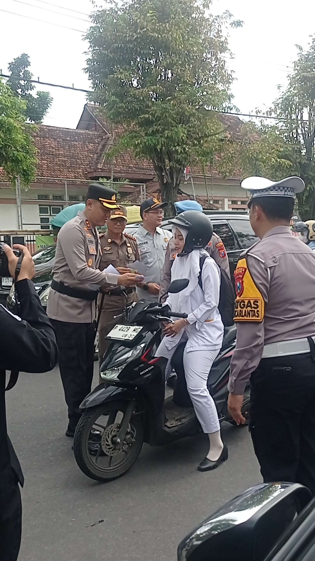 Kapolres Jember AKBP Bobby Adimas membagikan stiker tentang operasi zebra semeru kepada pengendara (Foto: Rusdi/Ngopibareng.id)