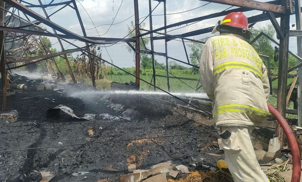Petugas Damkar Kabupaten Probolinggo sedang memadamkan sisa-sisa api yang membakar kandang ayam. (Foto: Ikhsan Mahmudi/Ngopibareng.id)