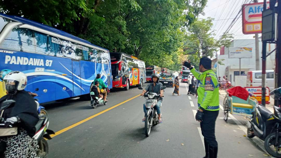 Kanit Turjawali bersama petugas Satlantas Polres Tuban melakukan pengaturan arus lalu lintas. (Foto: Khoirul Huda/Ngopibareng.id)