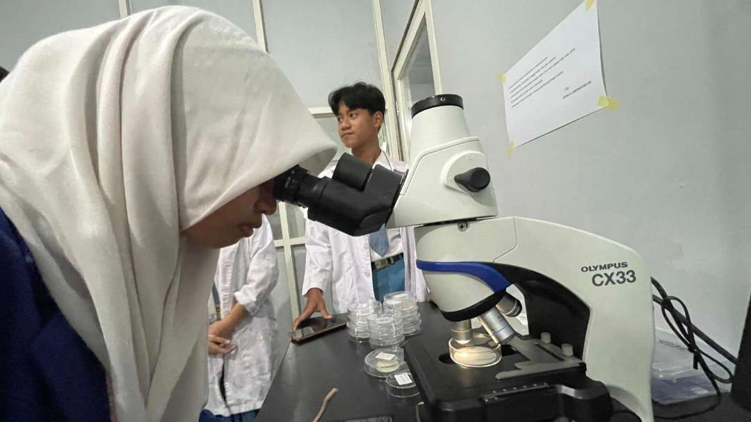 Seorang siswa SMA Negeri 1 Driyorejo yang melihat kandungan mikroplastik. (Foto: Ecoton)