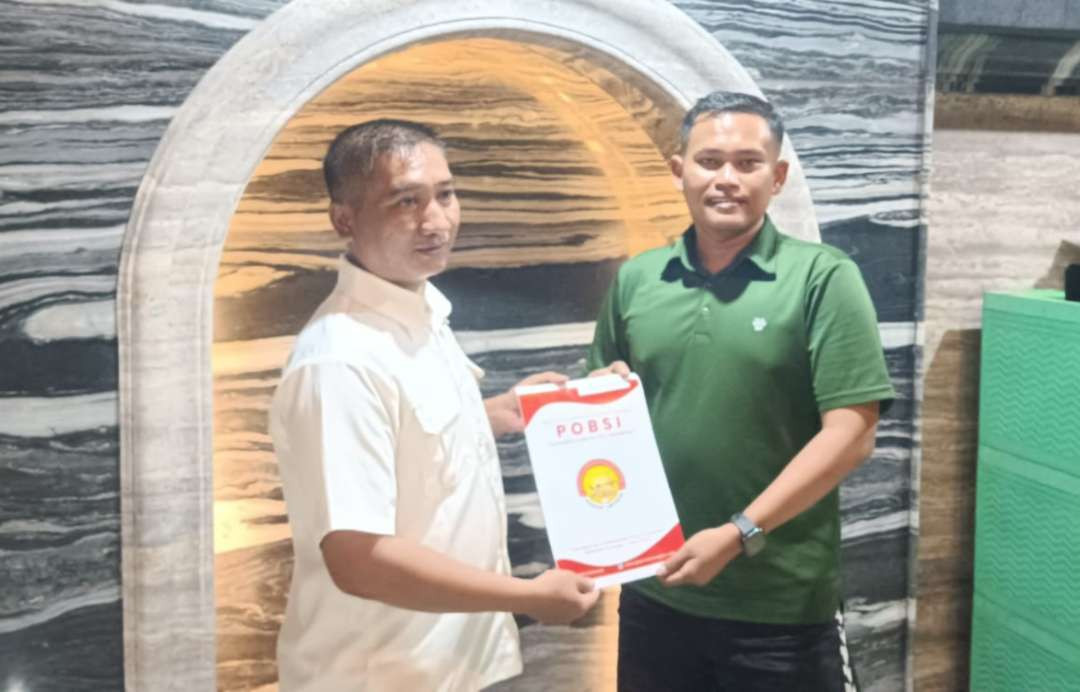 Ketua Harian POBSI Lamongan Arman menyerahkan SK Venue yang diterima perwakilan MHS Pool & Cafe, Dimas Setiawan, betkaus hijau  (Foto:Istimewa)