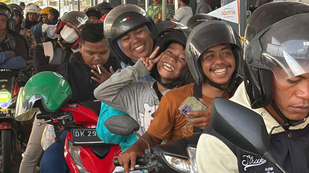 Seorang keluarga pemudik yang akan kembali ke Bali tampak gembira ketika antre untuk naik kapal penyeberangan di Pelabuhan Ketapang, Banyuwangi. (Foto: Muh Hujaini/Ngopibareng.id)