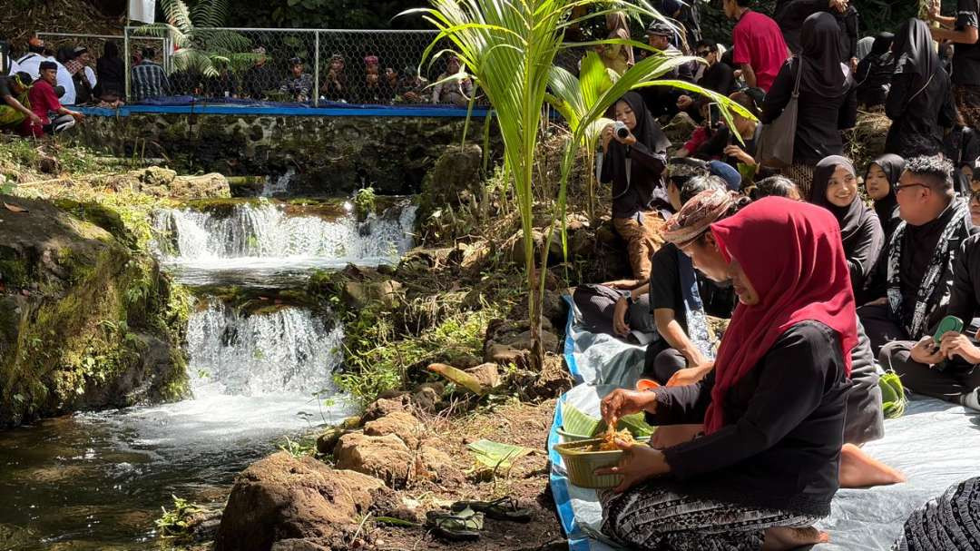 Warga menyantap makanan dalam ithuk di dekat mata air Kajar. (Foto: Muh Hujaini/Ngopibareng.id)
