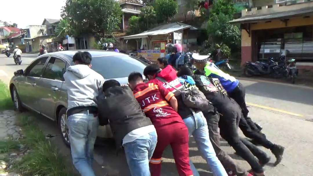 Polisi bantu dorong mobil warga yang mogok, implementasi salah satu tugas Polri melindungi masyarakat. (Foto: Istimewa)