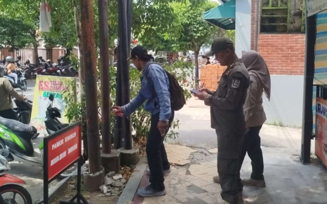Petugas gabungan dari Satpol PP dan Damkar serta PUPR-PRKP menandai tiang provider atau internet yang diduga tidak berizin dengan cat semprot warna merah (Foto: Istimewa)