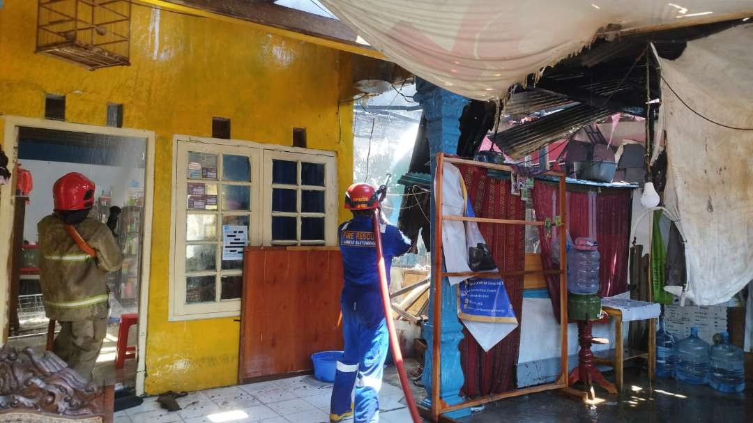 Petugas pemadam kebakaran terus menyemprotkan air untuk memastikan api benar-benar padam. (Foto: Muh Hujaini/Ngopibareng.id)